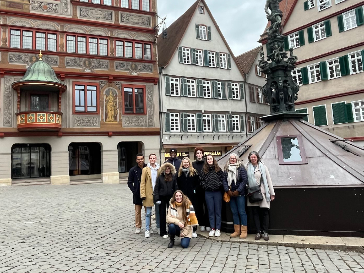 Eine Gruppe Menschen steht auf dem Markplatz in Tübingen vor dem Rathaus.