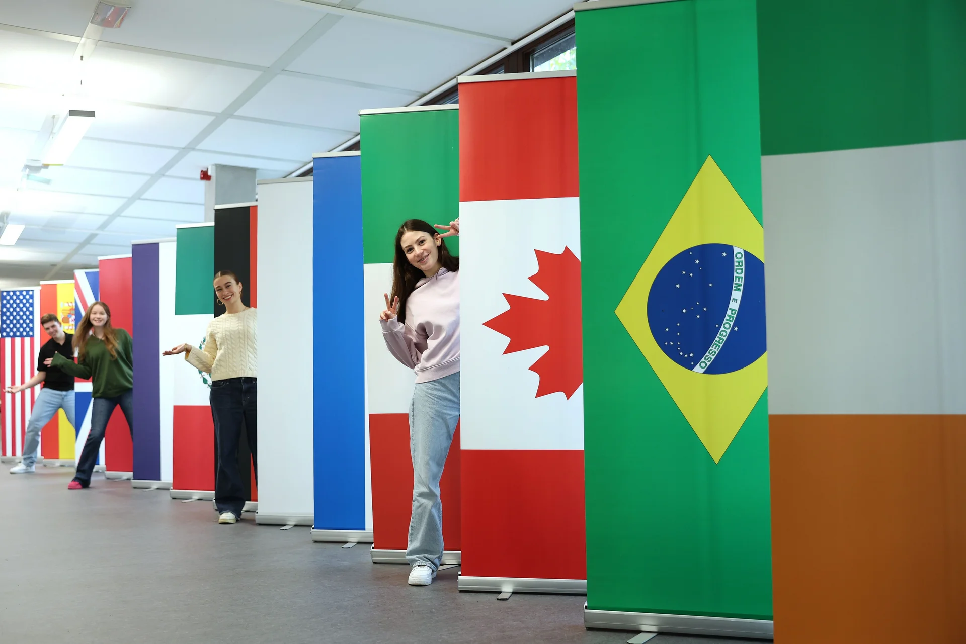Students posing behind the flags of countries of the partner universities of ESB Business School.