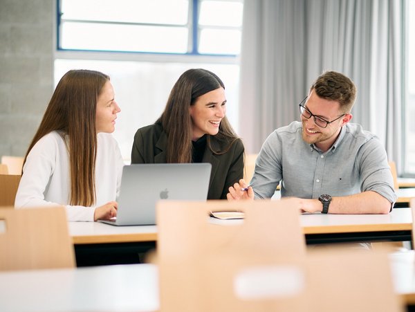 International Management Part-Time students at the ESB Business School chatting in a lecture room.