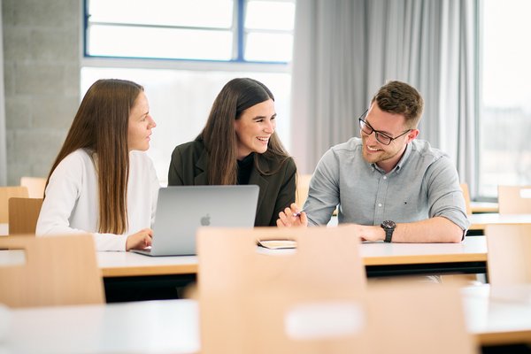 International Management Part-Time students at the ESB Business School chatting in a lecture room.