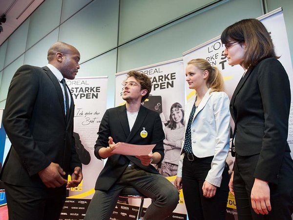 International Retail Management Professor und Student im Gespräch mit einem Unternehmensvertreter auf der internationalen business fair 