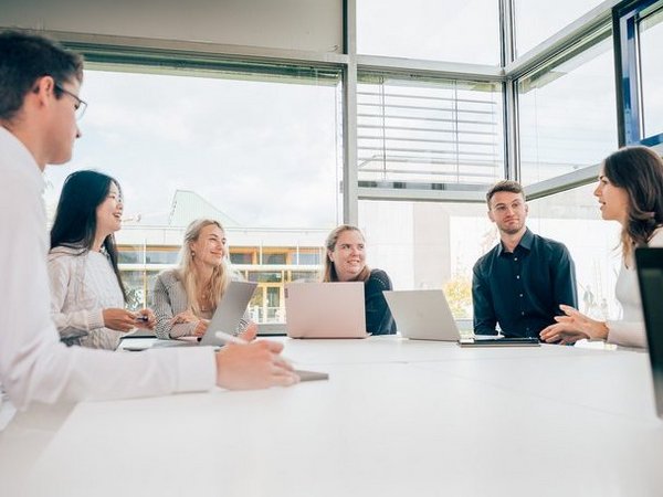 International Management. Für Offiziere und Professionals im Gespräch mit einem Vertreter eines Partnerunternehmens studierende der ESB Business School unterhalten sich in einem Vorlesungsraum.