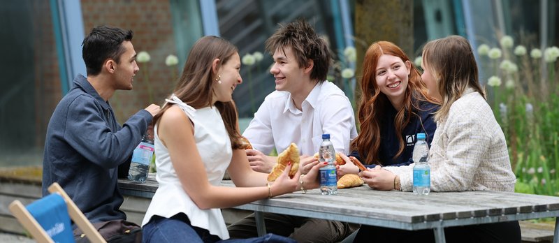 Students enjoying their break together sitting outside ion campus